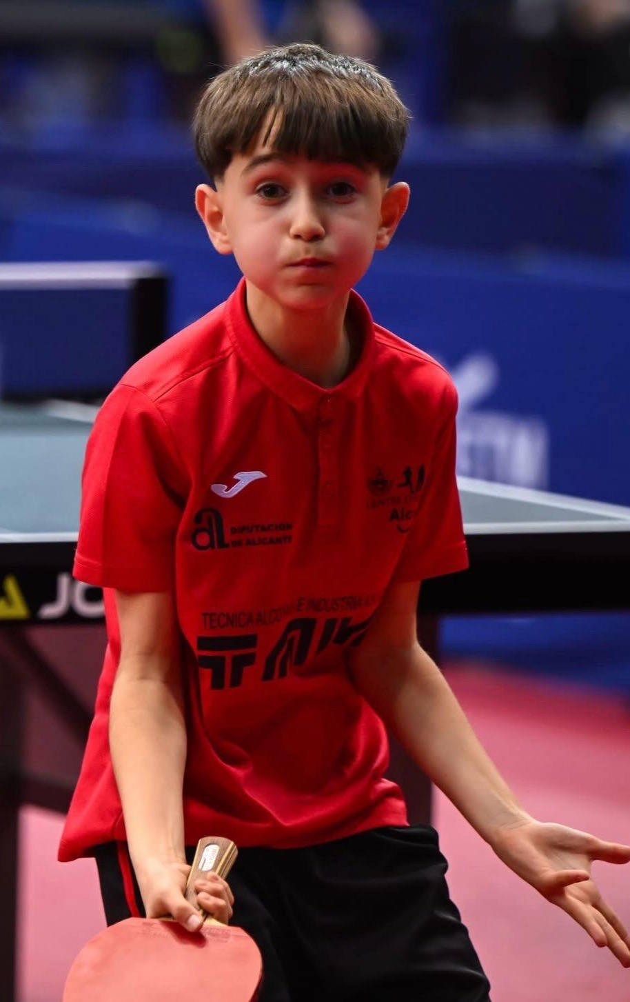 Mateo mostrando orgulloso su medalla y trofeo de campeón en el podio